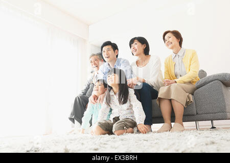 Trois générations de la famille japonaise sur le canapé dans le salon Banque D'Images