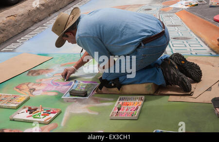 Un homme adulte peinture artiste à la craie à la 'vieille Santa Barbara Mission" au cours de l'I-Madonnari, festival street painting Banque D'Images