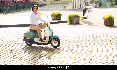 Jeune homme de la trottinette en ville Banque D'Images