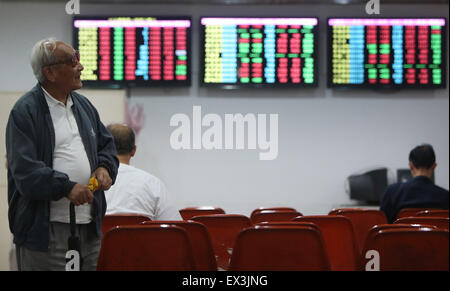 Shanghai, Chine. 6 juillet, 2015. Un homme marche à un marché de stocks à Shanghai, la Chine orientale, le 6 juillet 2015. Les actions chinoises ont montré des signes de stabilisation lundi, le Shanghai Composite Index de référence de 2,41 pour cent la hausse pour finir à 3 775,91 points. Cependant, le composant de Shenzhen a perdu 1,39 pour cent de l'indice pour clôturer à 12 075,77 points. Le ChiNext, la Chine a suivi de l'indice Nasdaq-style conseil d'entreprises en croissance, a plongé de 4,28  % fin à 2 493,83 points. Credit : Pei Xin/Xinhua/Alamy Live News Banque D'Images