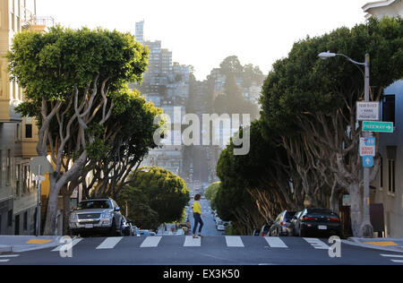 Une femme marche à travers un Xing sur Lombard Street à San Francisco, Californie. Banque D'Images