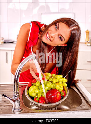 Femme lave-fruit à la cuisine. Banque D'Images