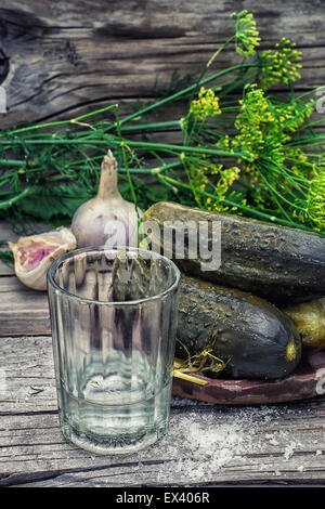 Concombres à l'aneth et verre de vodka sur fond de bois dans un style campagnard.Photo.teinté Selective focus Banque D'Images