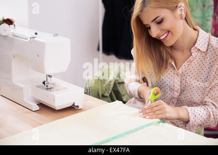 Happy female designer tissu coupe dans l'atelier Banque D'Images