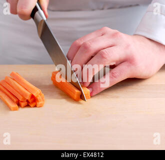 Couper les carottes en lanières avec grand couteau, close-up Banque D'Images