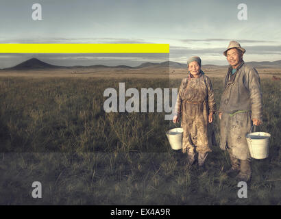 Les agriculteurs du bassin de Mongolie couple holding et posant dans le domaine. Banque D'Images