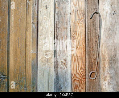 Une partie d'un mur en bois, avec des clous rouillés et barre en métal pour tirer. Banque D'Images