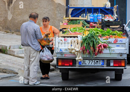 Femme d'acheter des fruits et légumes à un vendeur de rue, Sicile, Italie Banque D'Images