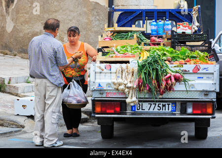 Femme d'acheter des fruits et légumes à un vendeur de rue, Sicile, Italie Banque D'Images