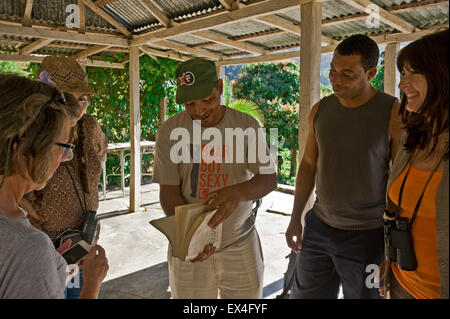 Vue horizontale d'un accompagnateur touristes montrant des images de Fidel Castro dans une réserve en parc national Turquino, Cuba. Banque D'Images