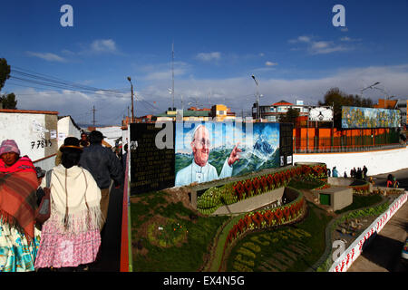 La Paz, Bolivie, le 6 juillet 2015. Les femmes Aymara dans La Ceja, El Alto devant une murale peinte récemment du Pape François avec une prière pour sa bonne arrivée en Bolivie. Le pape François se rendra à El Alto et La Paz le 8 juillet au cours de sa 3 journée à la Bolivie. Banque D'Images