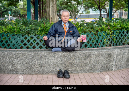 Vieil homme méditant chinois à Hong Kong, Chine Banque D'Images