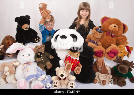 Collection d'animaux naturalisés avec 2 ans boy holding up son ours en peluche, et sa sœur de 5 ans Banque D'Images