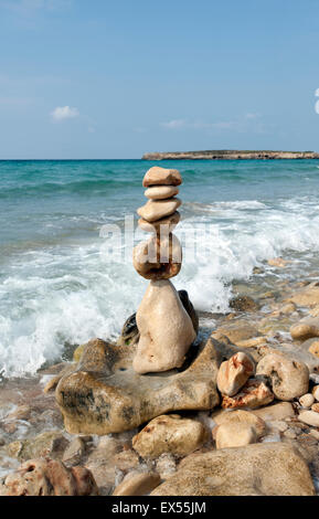 Un tas de pierres de plage fait en un tour de sculpture sur le rivage de Sant Tomas Beach sur l'île de Minorque espagne Banque D'Images