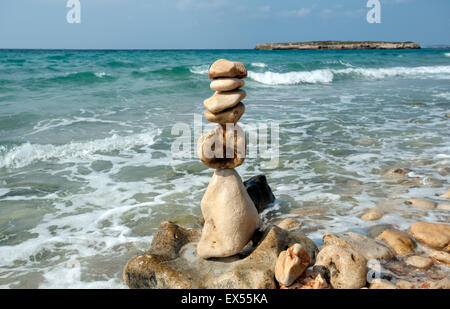 Un tas de pierres de plage fait en un tour de sculpture sur le rivage de Sant Tomas Beach sur l'île de Minorque espagne Banque D'Images