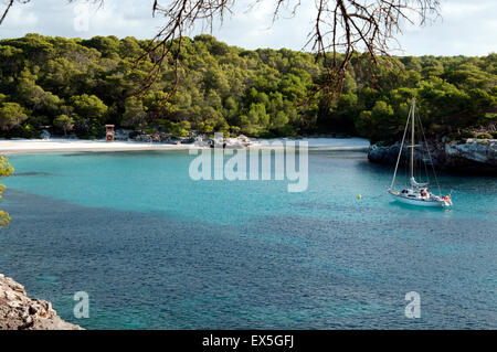 Un bateau à la location dans le calme des eaux turquoise du Cala Turqueta sur l'île de Minorque espagne Banque D'Images