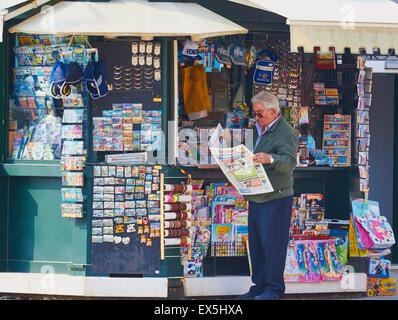 L'homme de la lecture d'un journal sportif italien devant un kiosque de souvenirs et nouvelles Burano Lagune de Venise Vénétie Italie Europe Banque D'Images