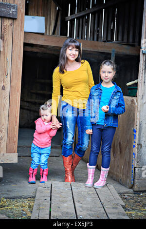 Une famille agricole avec des oeufs en face de la ferme Banque D'Images