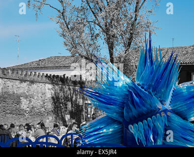 Coin des clients en plein air à côté d'une sculpture de verre bleu géant Campo Santo Stefano Murano Lagune de Venise Vénétie Italie Europe Banque D'Images