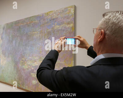 Homme Prenant des photos Claude Monet les nénuphars au Musée d'Art Moderne de l'intérieur, New York Banque D'Images