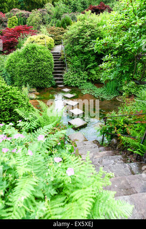 Étapes et jalons menant à travers un ruisseau au parc à thème Alton Towers Estate Gardens Staffordshire England UK Banque D'Images