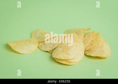Un plan macro sur mini croustilles de pommes de terre sur un fond vert. Banque D'Images