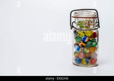 Pot en verre rempli de billes de verre coloré avec couvercle fermé le fil métallique Banque D'Images