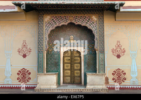 Porte en laiton avec de délicates peintures murales dans la cour de la Chandra Mahal City Palace, Jaipur, Rajasthan, Inde Banque D'Images