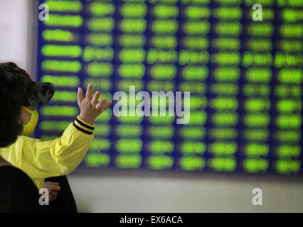 Beijing, Chine. 08 juillet, 2015. Un investisseur prend un enfant à une bourse en Nantong, province du Jiangsu, Chine, le 8 juillet 2015. Le CSI300 index des plus grandes sociétés cotées à Shanghai et Shenzhen fermer en baisse de 6,8 pour cent, tandis que le Shanghai Composite a chuté de 5,9 pour cent. Credit : Panda Eye/Alamy Live News Banque D'Images