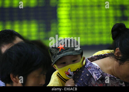 Beijing, Chine. 08 juillet, 2015. Un investisseur prend un enfant à une bourse en Nantong, province du Jiangsu, Chine, le 8 juillet 2015. Le CSI300 index des plus grandes sociétés cotées à Shanghai et Shenzhen fermer en baisse de 6,8 pour cent, tandis que le Shanghai Composite a chuté de 5,9 pour cent. Credit : Panda Eye/Alamy Live News Banque D'Images