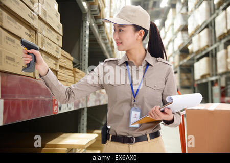 Jeune femme avec des boîtes de lecture lecteur code barre Banque D'Images