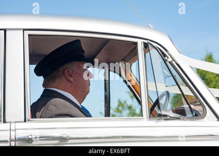 La conduite du chauffeur, voiture de mariage à côté de l'arrêt aux feux de circulation en Juillet Banque D'Images