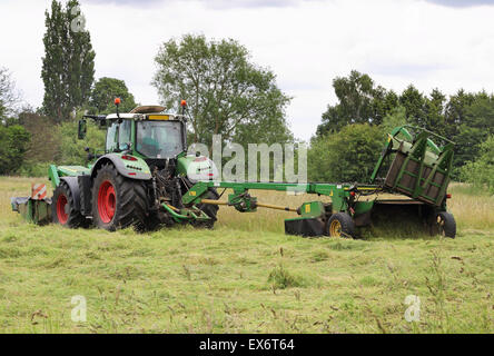 Tracteur avec coupe-herbe de tonte d'herbe dans un champ Banque D'Images