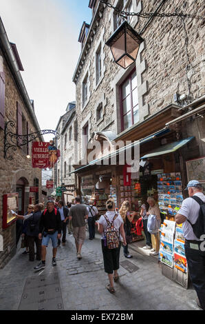 Les touristes restaurants dans l'étroite rue principale du Mont St Michel, Normandie, France Banque D'Images