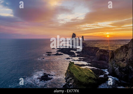 Coucher de soleil sur la mer et les piles de Londrangar Thufubjarg falaises, péninsule Snaefellnes, Islande. Banque D'Images