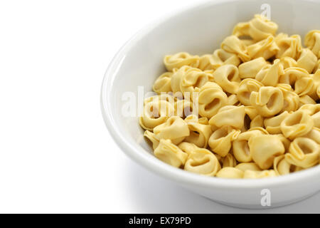 Dans un bol de pâtes tortellini cru isolé sur fond blanc Banque D'Images