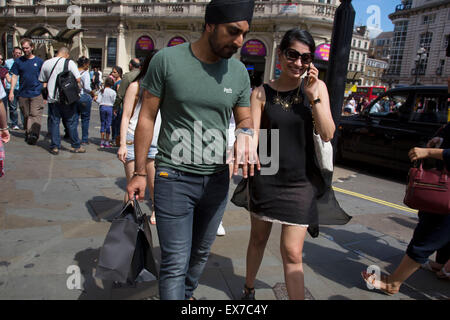 L'été à Londres, Angleterre, Royaume-Uni. Hot spot touristique de Piccadilly Circus l'espace public dans le West End de Londres. Construit en 1819 pour relier la rue Regent à Piccadilly. Ceci est connu comme l'un des sites les plus célèbres de Londres et où les touristes se rassemblent dans leurs milliers spécialement les jours de soleil. Banque D'Images