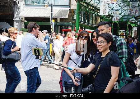 Les jeunes filles qui autoportraits, Borough Market, London. L'Angleterre. Banque D'Images