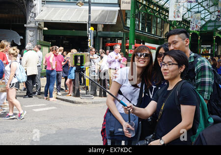 Les jeunes filles qui autoportraits, Borough Market, London. L'Angleterre. Banque D'Images