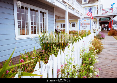 Galeries et boutiques d'artisanat avec clôture blanche sur la pittoresque rue principale au centre-ville de Mendocino, Californie Banque D'Images