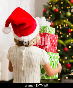 Girl (6-7) holding pile de cadeaux de Noël Banque D'Images