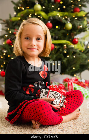 Portrait of Girl (6-7) holding Christmas present Banque D'Images