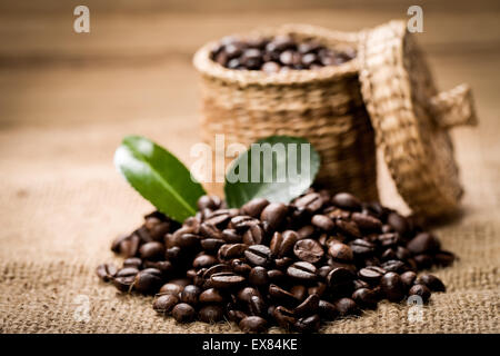 Tas de grains de café et cuillère en bois dans le jar Banque D'Images