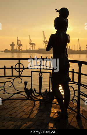 Une statue de la mère et son enfant attendent le retour de leur mari. la statue est silhouetté contre l'aube lumière à Odessa, ukra Banque D'Images