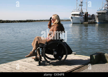 Femme à l'aide d'un fauteuil roulant sur un quai dans le fleuve Fraser Banque D'Images