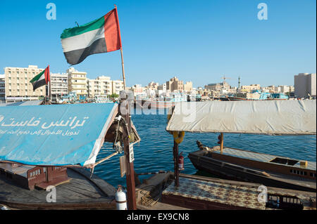Dubaï, Émirats arabes unis - 22 octobre 2014 : Les eau drapeau sur le côté de la Bur Dubai Creek survole un embarcadère pour une abra traditionnel ferry. Banque D'Images
