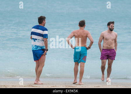 Trois des vacanciers sur la plage de Fistral, Newquay, Cornwall. Banque D'Images