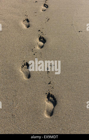 Des traces de pas dans le sable sur la plage de Sennen, Cornwall. Banque D'Images