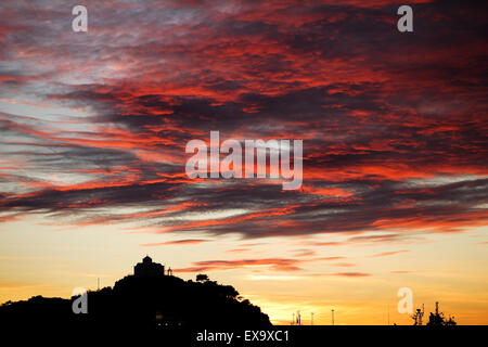 Magnifique coucher de soleil vu de couleurs chaudes cloud Tourkikos Bay et de la chapelle de Saint Nicolas sur la colline. L'île de Lemnos, en Grèce. Banque D'Images