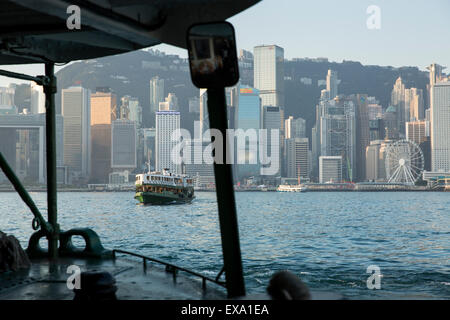 La Chine, Hong Kong, l'embarcadère des ferries Star motors à travers le port de Hong Kong avec des toits de la ville en arrière-plan au lever du soleil sur l'hiver matin Banque D'Images